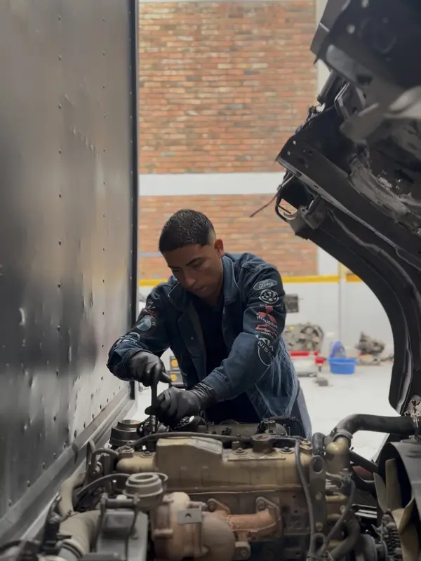 Un mecánico trabajando en un motor dentro del taller
